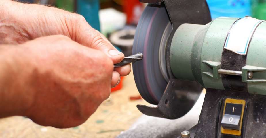 Worker re-sharpening black oxide drill bits